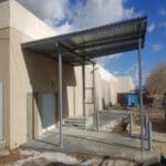 A building with a metal roof and concrete steps.