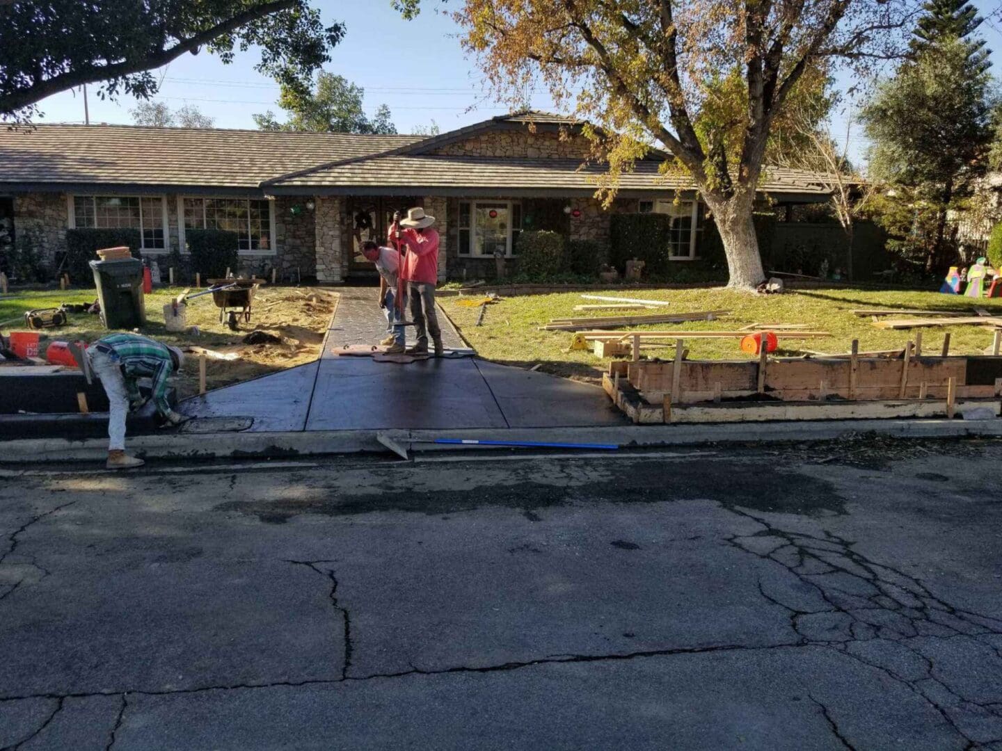 A couple of people standing on top of a driveway.