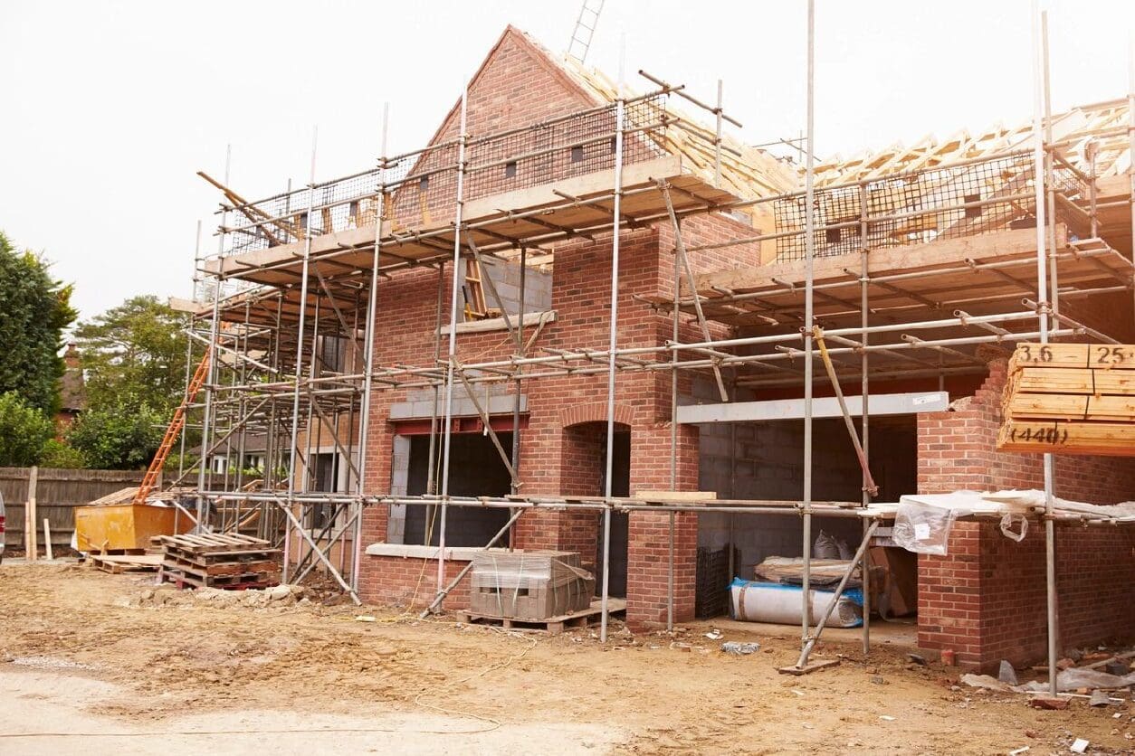 A brick house under construction with scaffolding around it.