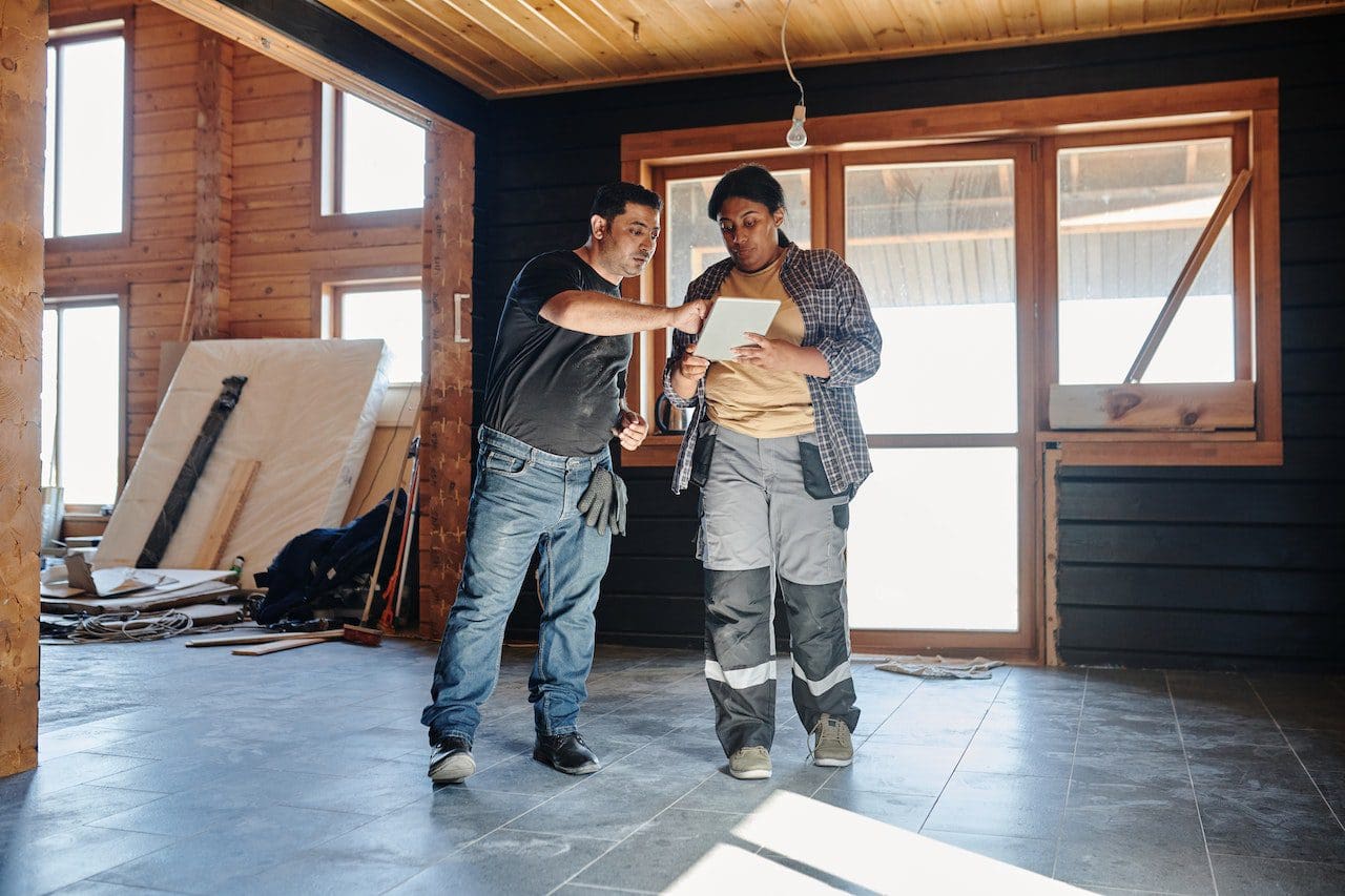 Two men standing in a room with construction equipment.