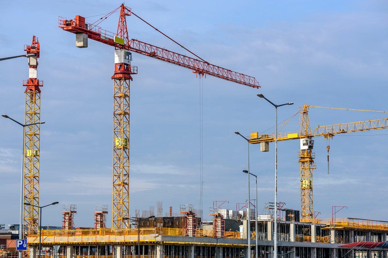 A group of cranes on top of a building.