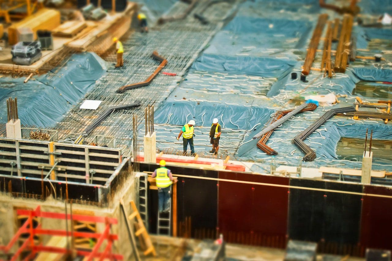 A group of construction workers standing on top of a building.